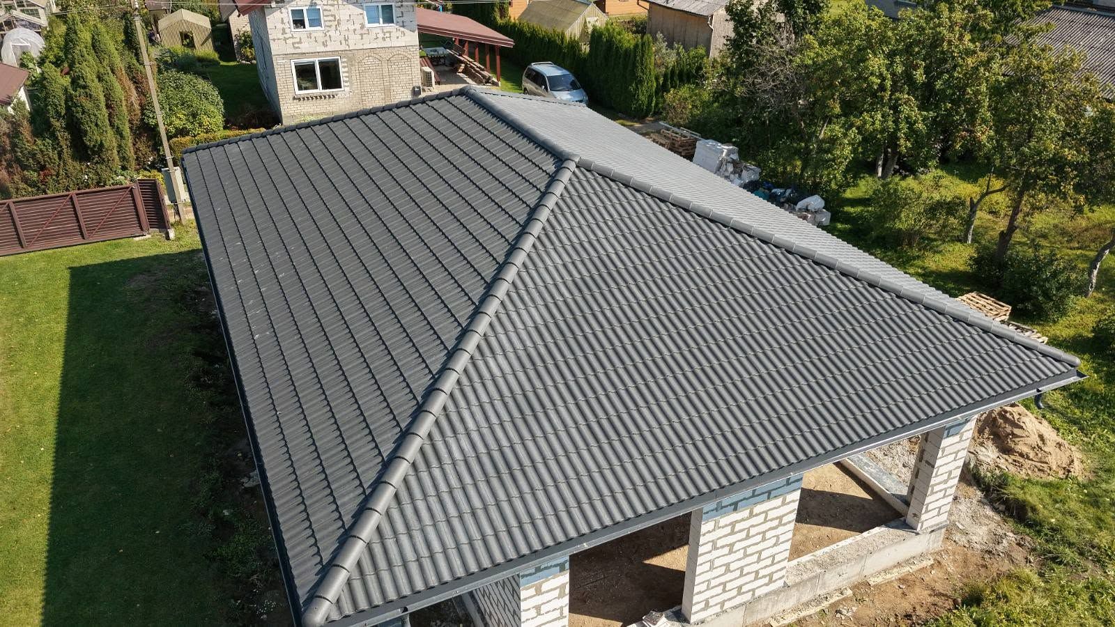 Keturšlaitis stogas su tamsia valcuota skarda – vaizdas iš drono